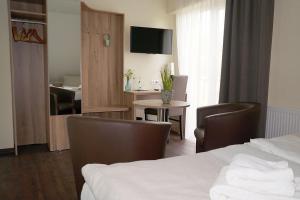 奥斯纳布吕克胡克斯米勒餐厅及酒店的酒店客房带一张床、一张桌子和椅子
