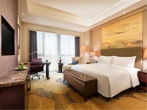 抚顺抚顺万达嘉华酒店的酒店客房设有一张大床和一张书桌。