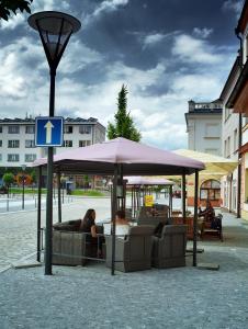 耶塞尼克Hotel Slovan的两个人坐在街上的伞下