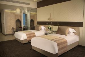 埃尔比勒Erbil Arjaan by Rotana的酒店客房,设有两张床和镜子