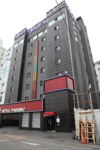 釜山V Motel Songdo的一座大建筑,上面有标志,上面写着酒店停车场的标志