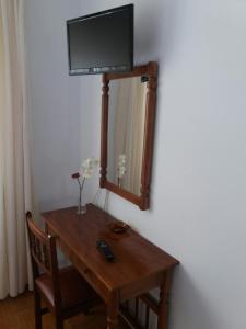 VimianzoPensión Vázquez的一张木桌,上面有电视机,镜子上