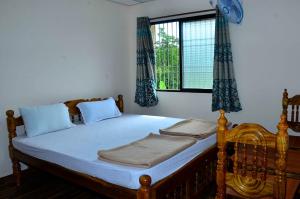 MāvingundiHills View Stay的一间卧室配有一张带蓝色窗帘的床和一扇窗户