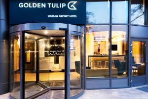华沙华沙机场金色郁金香酒店的带有玻璃旋转门的商店入口