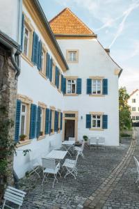 索梅拉Villa Sommerach的白色的建筑,设有蓝色百叶窗和桌椅