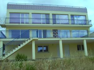 马桑Villa Ortiga的黄色的建筑,设有蓝色的阳台和楼梯