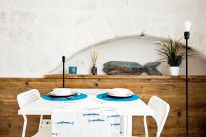 莫诺波利Borgo Albergo Capozzi 37的一张桌子、两把椅子和一张白色的桌子,上面有蓝色的板子