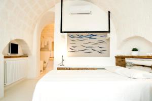 莫诺波利Borgo Albergo Capozzi 37的卧室配有一张床,墙上挂有绘画作品