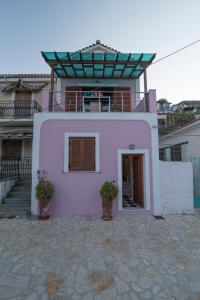 瓦西Odysseos St. Loft的前面有两株盆栽植物的粉红色房子