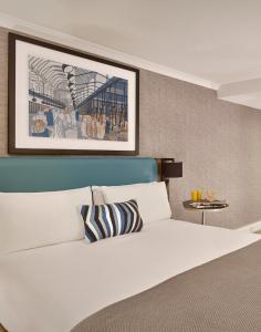 伦敦馨乐庭伦敦巴比肯酒店的卧室配有白色的床,墙上挂着一幅画