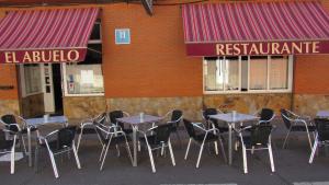 Trobajo del CaminoHostal Restaurante El Abuelo的一组桌子和椅子在餐厅前