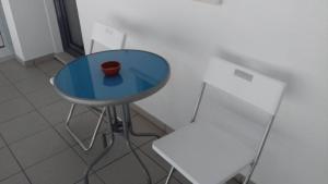 纳扎雷Vivenda Valverde的一张蓝色桌子,上面有花瓶,放在椅子旁边