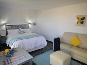 阿洛拉Casa Oasis的一间卧室配有一张床和一张沙发