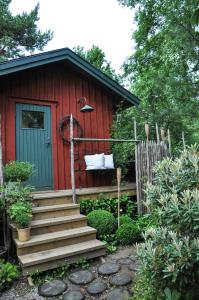 VeddigeHåkesgård Bed&Garden的红色小屋,设有通往小屋的楼梯