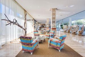 圣埃乌拉利亚热带花园公寓式酒店的一个带椅子和桌子的大堂以及一间窗户的房间