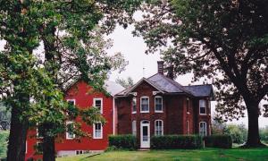 MuscatineStrawberry Farm B and B的前面有树木的红房子