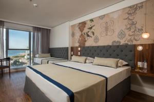 累西腓Hotel Luzeiros Recife的一间卧室设有一张大床和一个大窗户