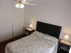 科尔多瓦Departamentos Córdoba Vaes的一间卧室配有一张床和两张带台灯的桌子。