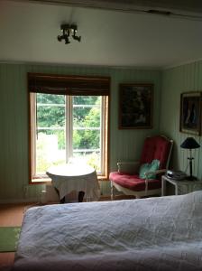 Västerlanda艾尔维贝肯酒店的卧室配有床、椅子和窗户。