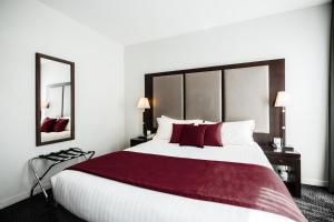 巴黎拉内公园酒店的酒店客房配有一张带红色枕头的大床