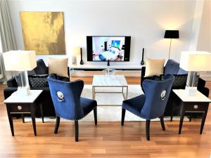 华沙MONDRIAN Luxury Suites & Apartments Market Square IV的客厅配有蓝色椅子和沙发