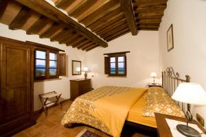 科尔托纳Fattoria Borgonuovo的一间带一张床的卧室,位于带木制天花板的房间内