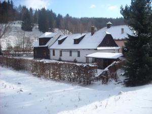 小莫拉夫卡Chalupa za Křížkem的一座白色的大房子,屋顶上积雪