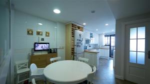 马亚达洪达Golf Apartment的一间设有白色桌椅和厨房的客房