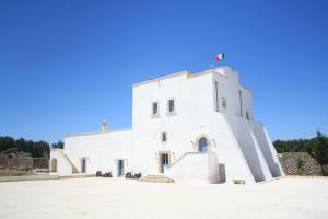 托雷圣苏桑纳Antica Masseria Torre Mozza的一座白色的建筑,前面有楼梯