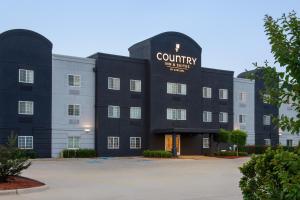 什里夫波特Country Inn & Suites by Radisson, Shreveport-Airport, LA的带有乡村酒店服务标志的建筑