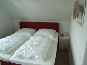 青斯特Piratennest-2的一张带两张白色床单和红色床头板的床