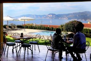 卡拉古诺内古斯图伊马里斯别墅酒店的两人坐在桌子上,享有水景