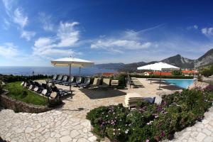 卡拉古诺内古斯图伊马里斯别墅酒店的一个带椅子和遮阳伞的庭院和一个游泳池