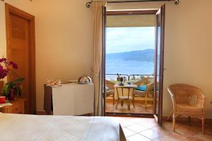 卡拉古诺内古斯图伊马里斯别墅酒店的一间卧室设有一扇门,可通往带桌子的阳台