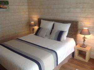勒泰克Les Rives du Bassin的一间卧室配有一张带白色床单和两盏灯的床。