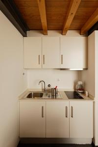 维塞乌Antiga Casa do Boi的厨房配有白色橱柜和水槽