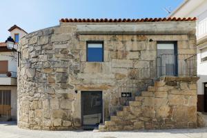 维塞乌Antiga "Casa do Porco"的石头建筑,有门和楼梯