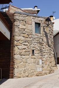 维塞乌Antiga "Casa do Porco"的一面有窗户的石头建筑