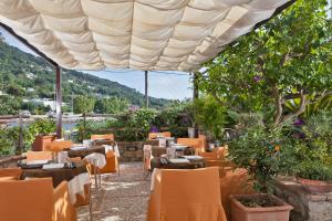 阿纳卡普里塞纳里亚酒店的餐厅设有大伞下桌椅