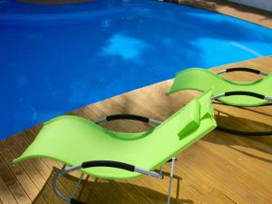 特鲁欧克比赫斯拉托奈勒旅馆的游泳池旁的绿椅