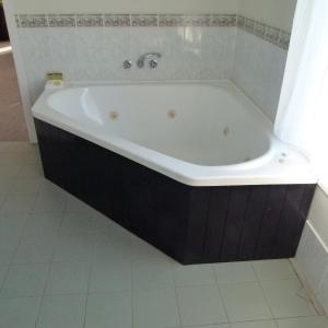 利斯莫尔利斯莫尔威尔逊汽车旅馆的带浴缸的浴室,铺有瓷砖地板