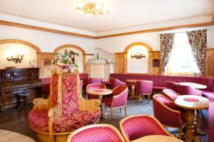 圣马蒂诺-迪卡斯特罗扎约兰达酒店的一间设有紫色桌椅的餐厅和一间酒吧