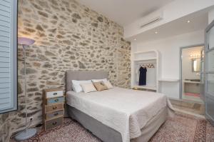 纳克索乔拉Naxos Center Houses的一间卧室设有一张床和石墙