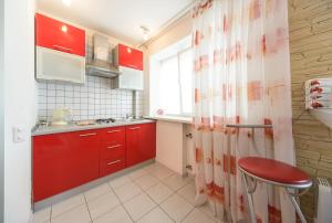 基辅萨克萨汉斯考霍合作伙伴旅馆的一间设有红色橱柜和红色凳子的小厨房