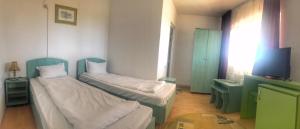 多亚马伊斯科皮昂综合旅馆的一间设有两张床和一台电视的房间