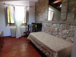 圣斯特凡诺·迪塞斯La Locanda sul Lago的一间卧室设有一张床和石墙