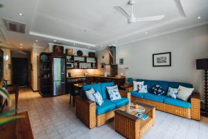 伊甸岛海蓝宝石酒店的一间带蓝色沙发的客厅和一间厨房