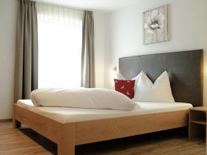 雷西亚Pension Apartment Erna的一间卧室配有带白色床单和红色枕头的床。