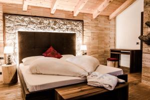 塞尔瓦迪加尔代纳山谷Garni Residence Soraiser的一间卧室设有一张大床和木墙