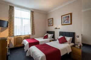 伦敦亚德里亚酒店的酒店客房设有两张床和窗户。